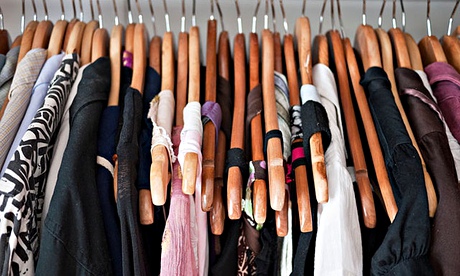 Clothes rail in cupboard, men's and women's clothing on wooden hangers